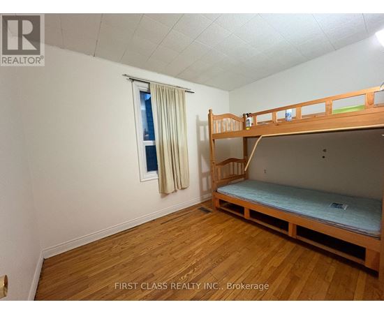 A bedroom with a bunk bed and a window with curtains.