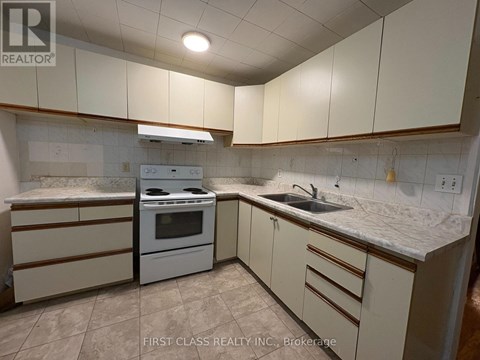 A kitchen with white cabinets and a marble countertop.