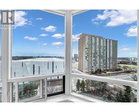 A view from a window looking out at a cityscape with a tall building in the distance.