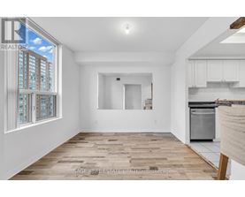 A spacious, empty room with wooden flooring and white walls.