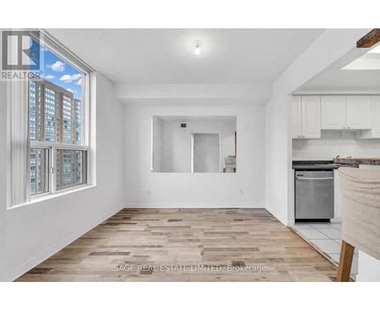 A spacious, empty room with wooden flooring and white walls.