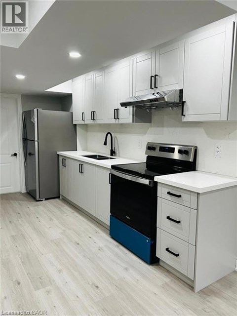 A modern kitchen with white cabinets and a blue drawer.