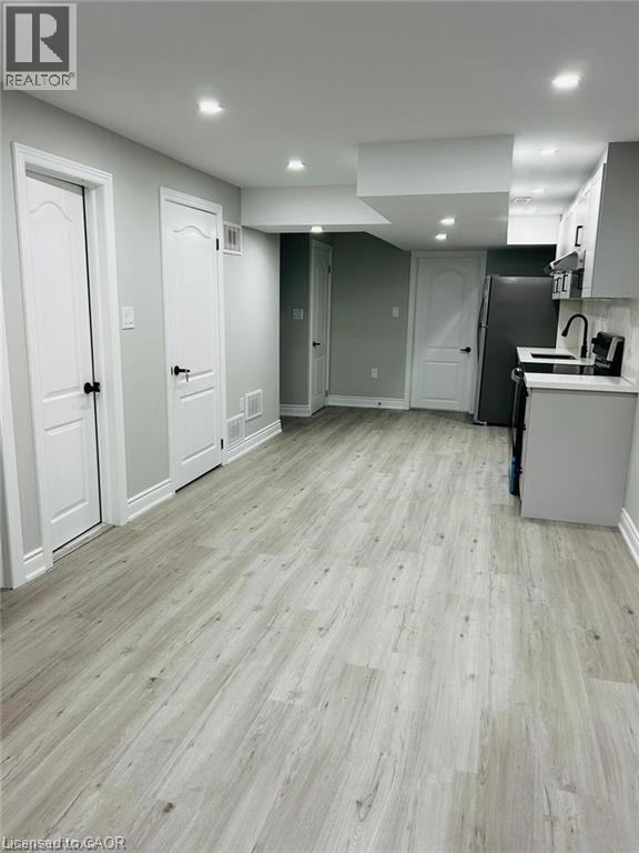 A kitchen with white cabinets and a wooden floor.
