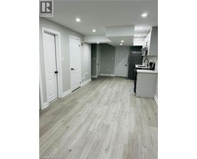A kitchen with white cabinets and a wooden floor.