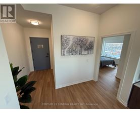 A room with a painting of trees on the wall and a bed in the other room.