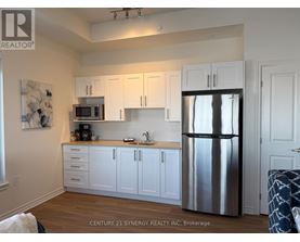 A kitchen with white cabinets and a stainless steel refrigerator.