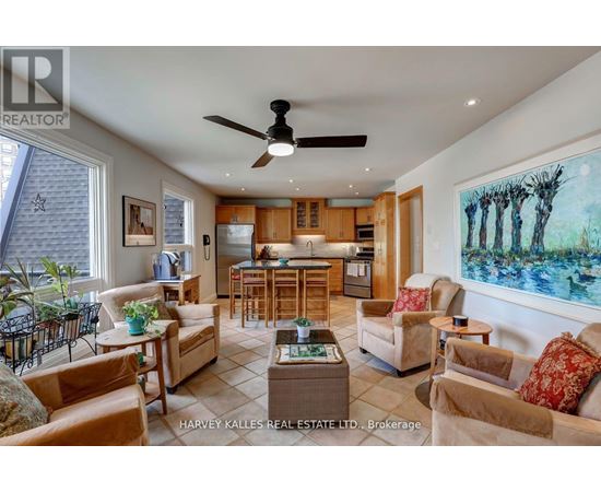 A living room with a ceiling fan and a painting on the wall.