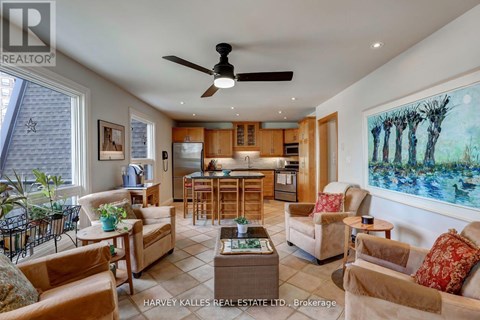 A living room with a ceiling fan and a painting on the wall.
