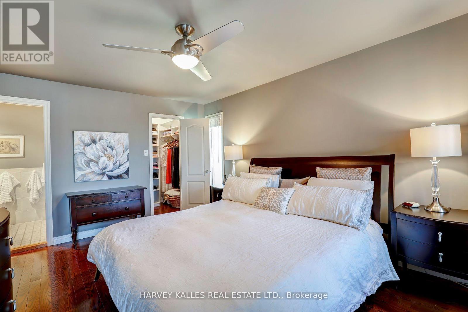 A bedroom with a large bed and a ceiling fan.
