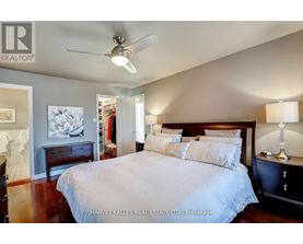 A bedroom with a large bed and a ceiling fan.