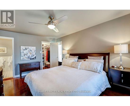 A bedroom with a large bed and a ceiling fan.