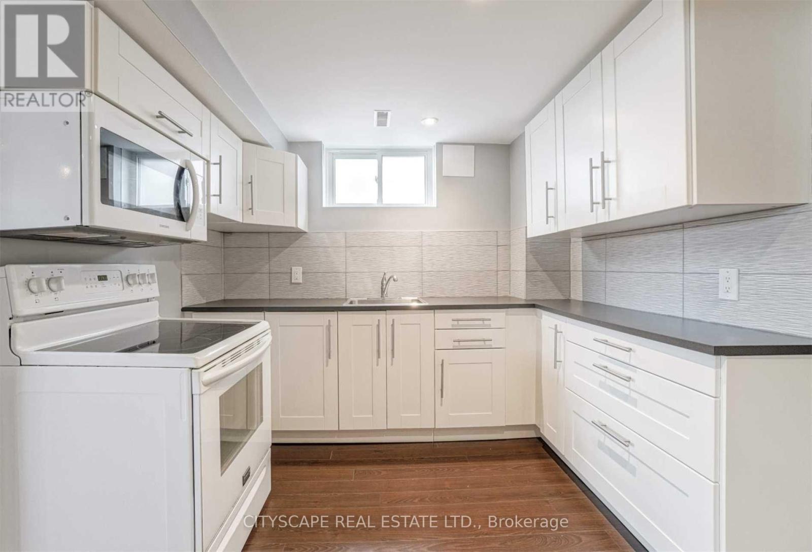 A kitchen with white appliances and cabinets.