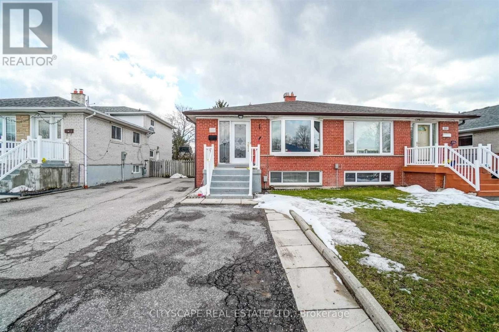 A real estate photo of a house with a driveway in front.