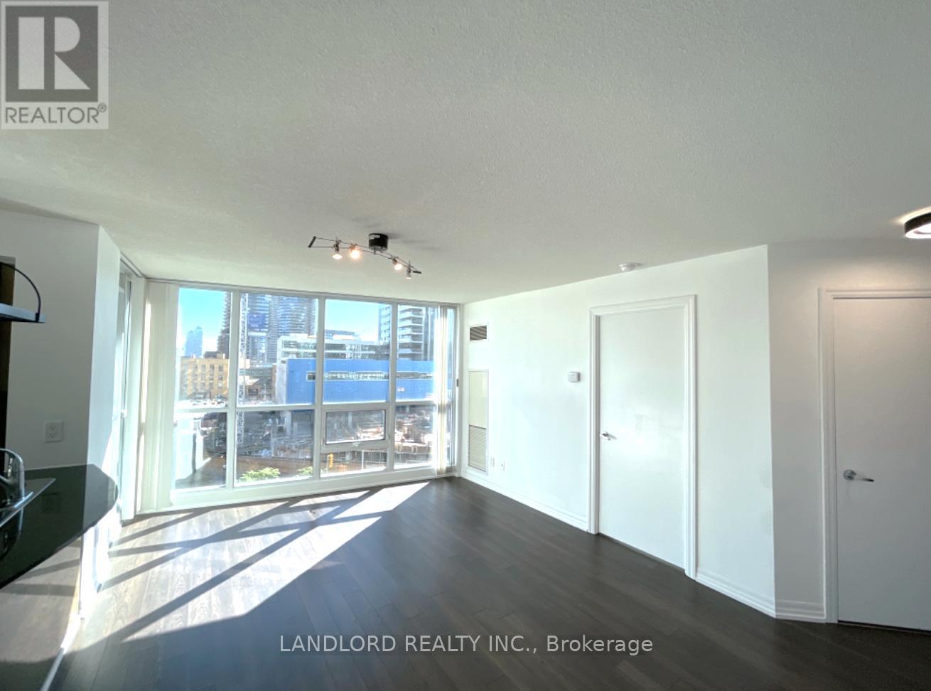 A spacious room with a view of the city through large windows.