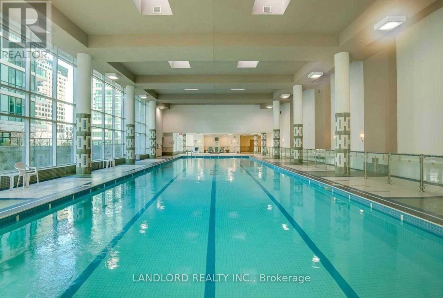 A large indoor swimming pool with a glass wall on one side.