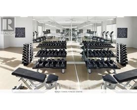 A gym with a variety of equipment including dumbbells and benches.