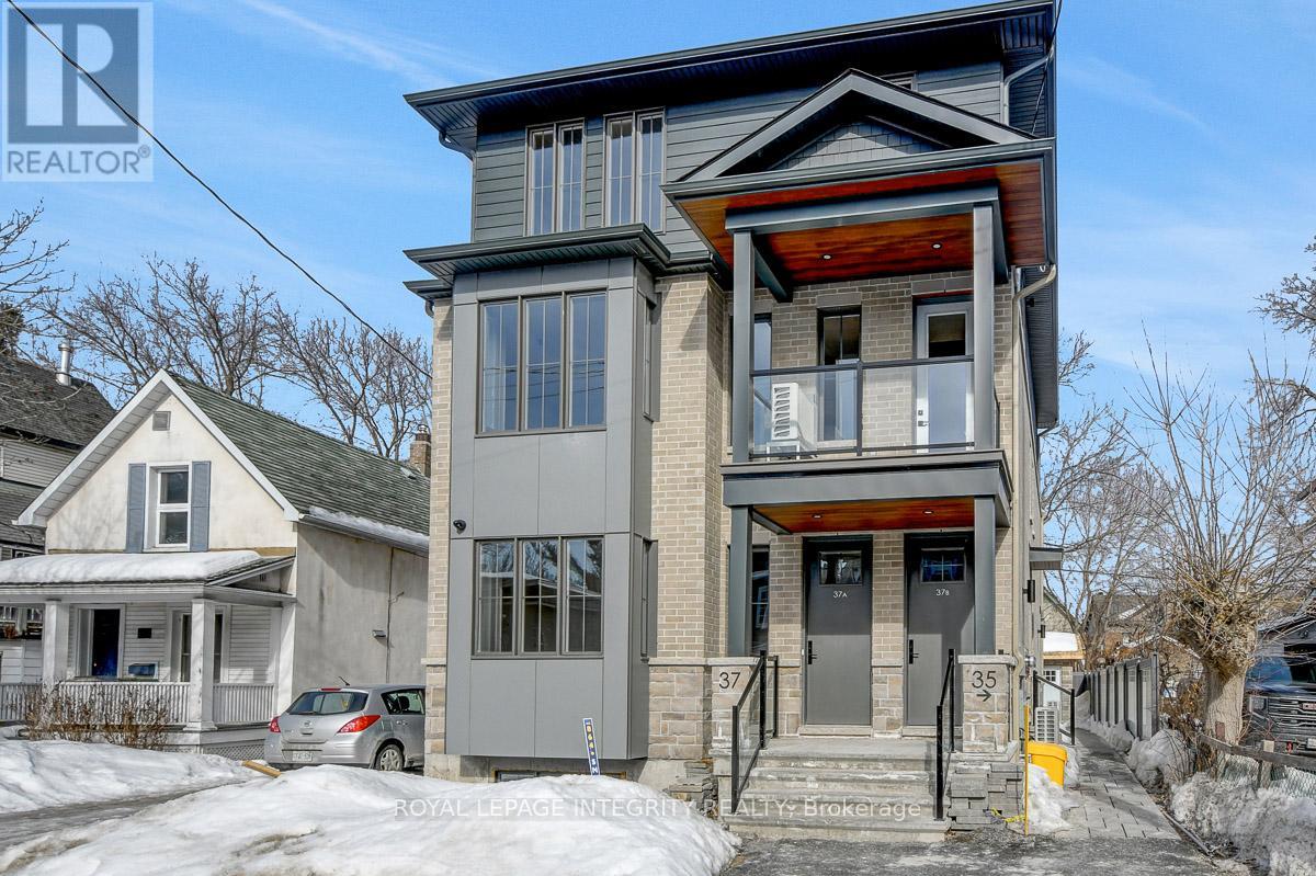 A two-story house with a grey and brown exterior is for sale.