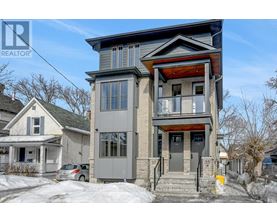 A two-story house with a grey and brown exterior is for sale.