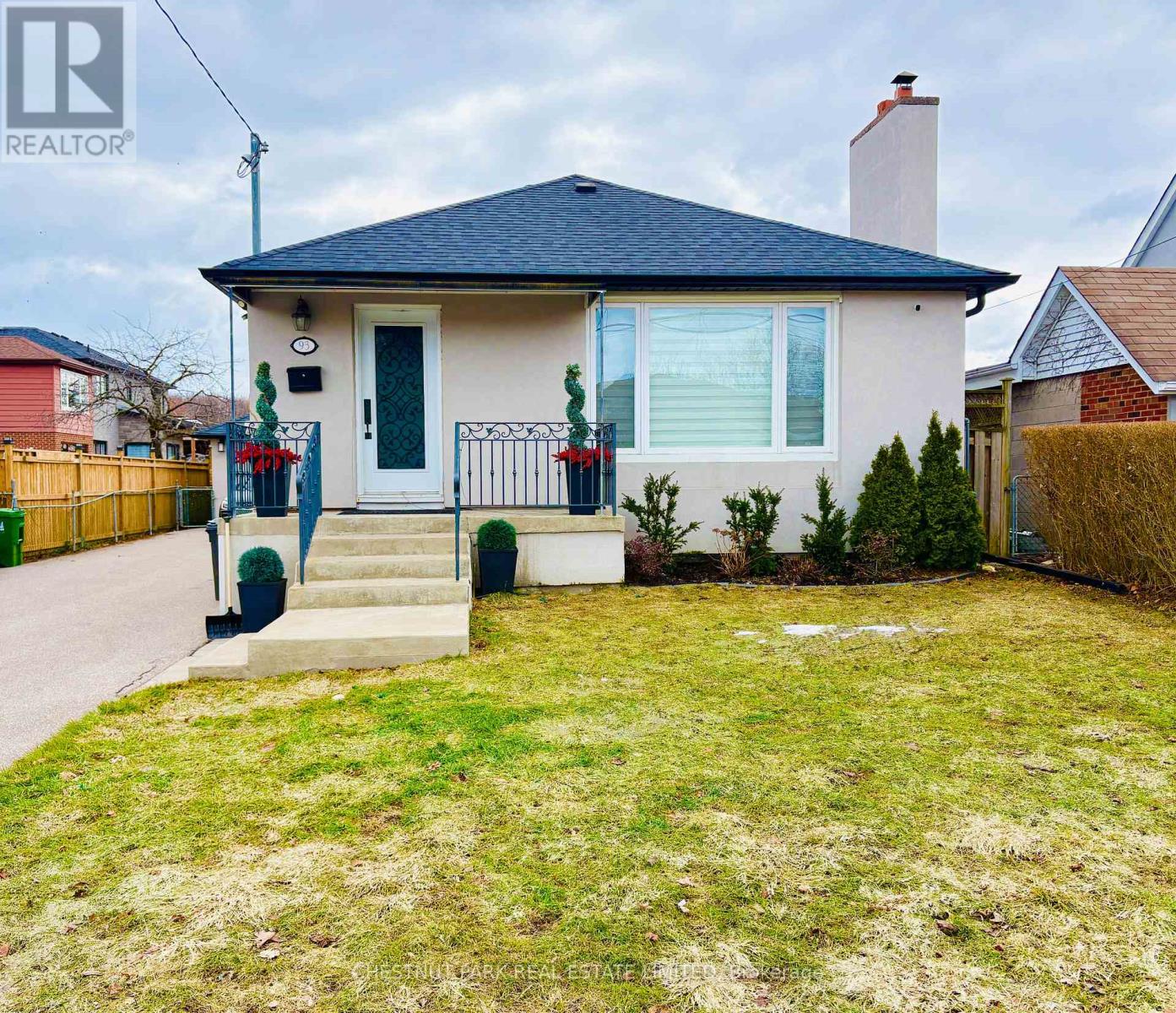 A house with a blue roof and a white door is for sale.