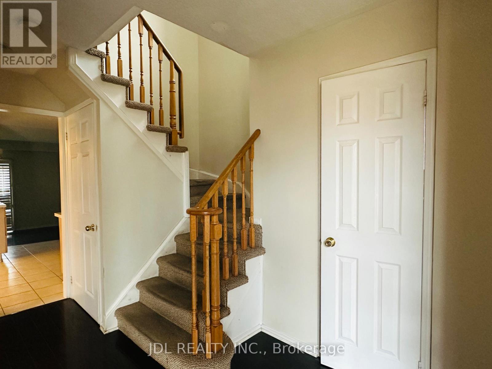 A staircase with a wooden banister and a white door.