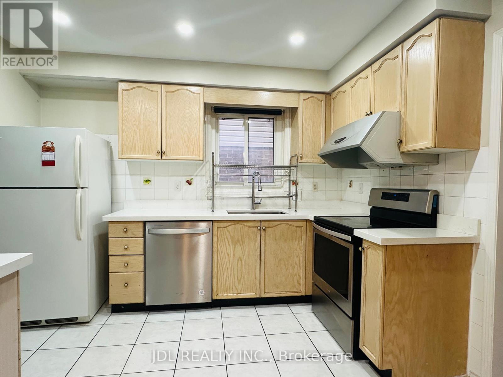 A kitchen with wooden cabinets and a white fridge.