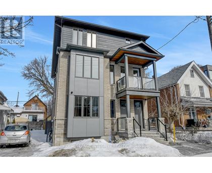 A grey house with a car parked in front of it.