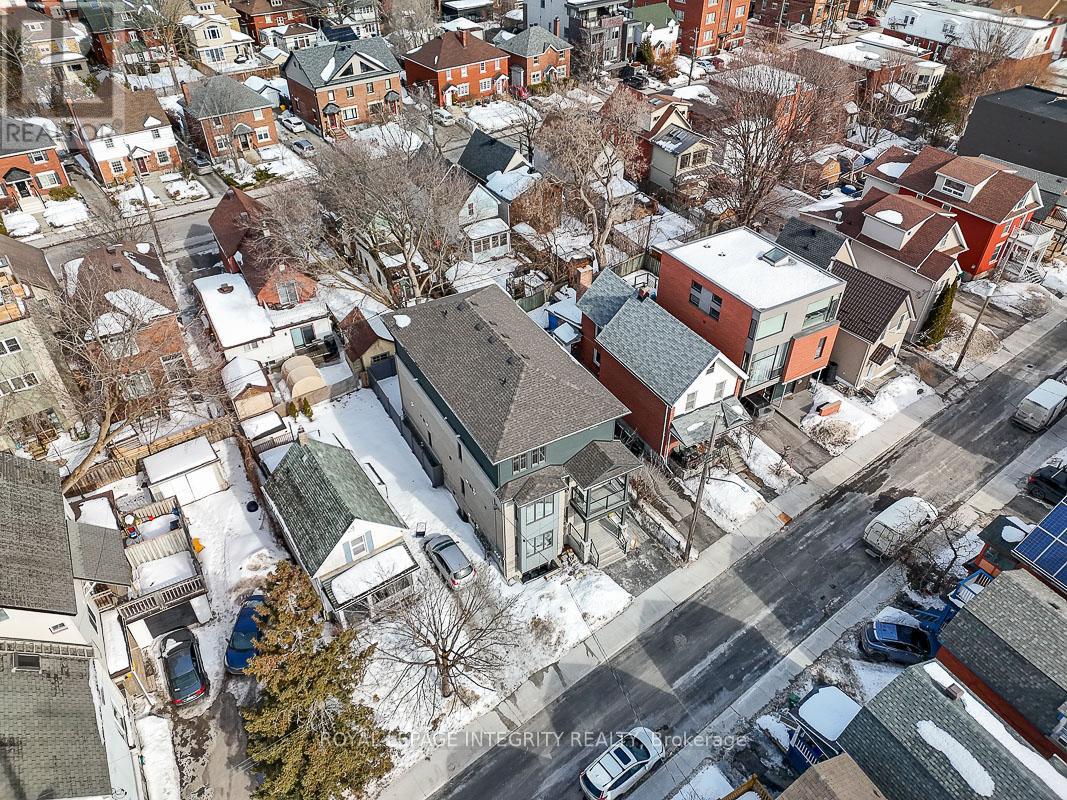 A winter scene of a residential area with houses and cars.