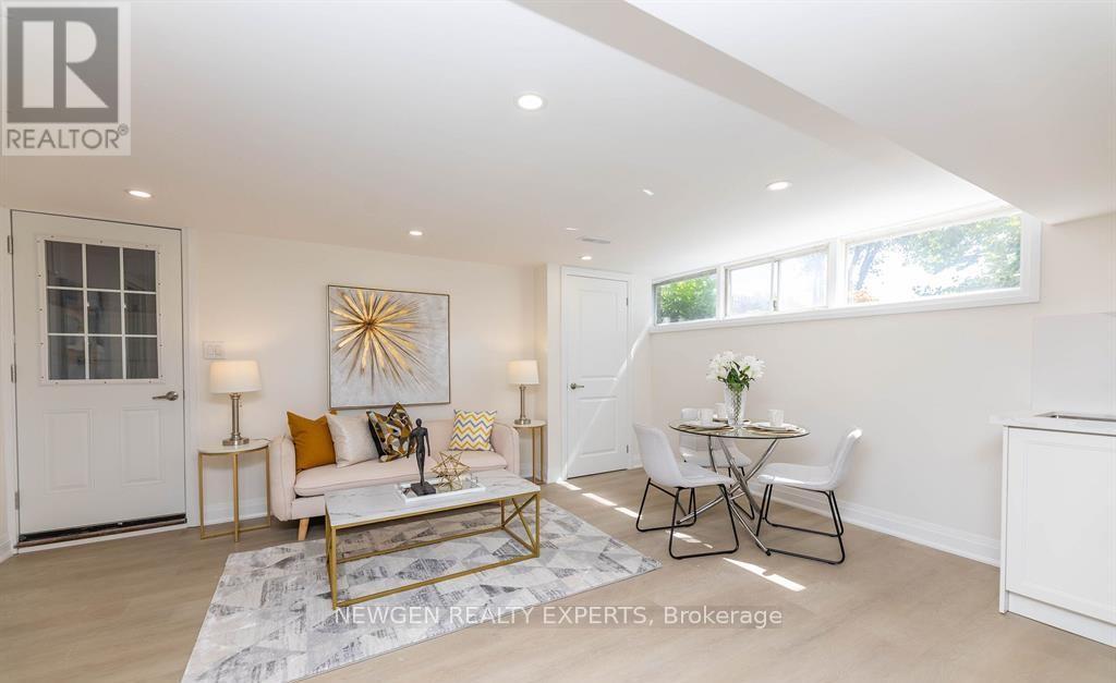 A well-lit, spacious living room with a white sofa, a coffee table, and a dining table set up.