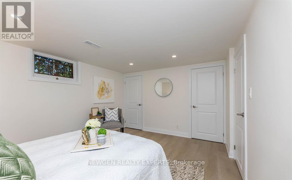 A bedroom with a bed, a mirror, and a window.