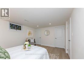 A bedroom with a bed, a mirror, and a window.