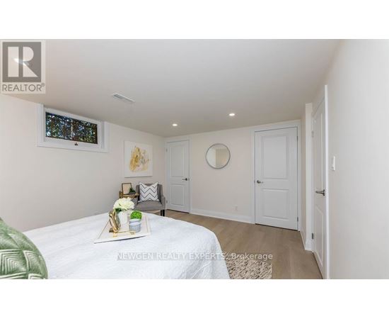 A bedroom with a bed, a mirror, and a window.