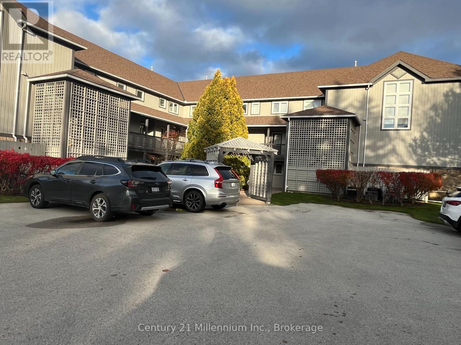 A parking lot with cars and a building in the background.