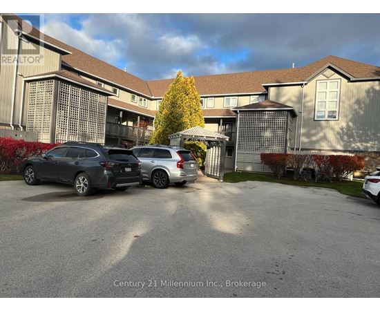 A parking lot with cars and a building in the background.