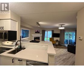 A kitchen with white countertops and a black stove top oven.