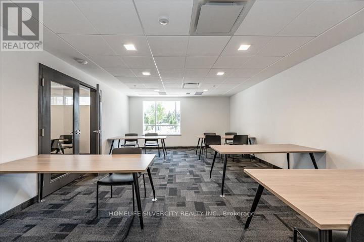 A conference room with a carpeted floor and a large table with chairs.