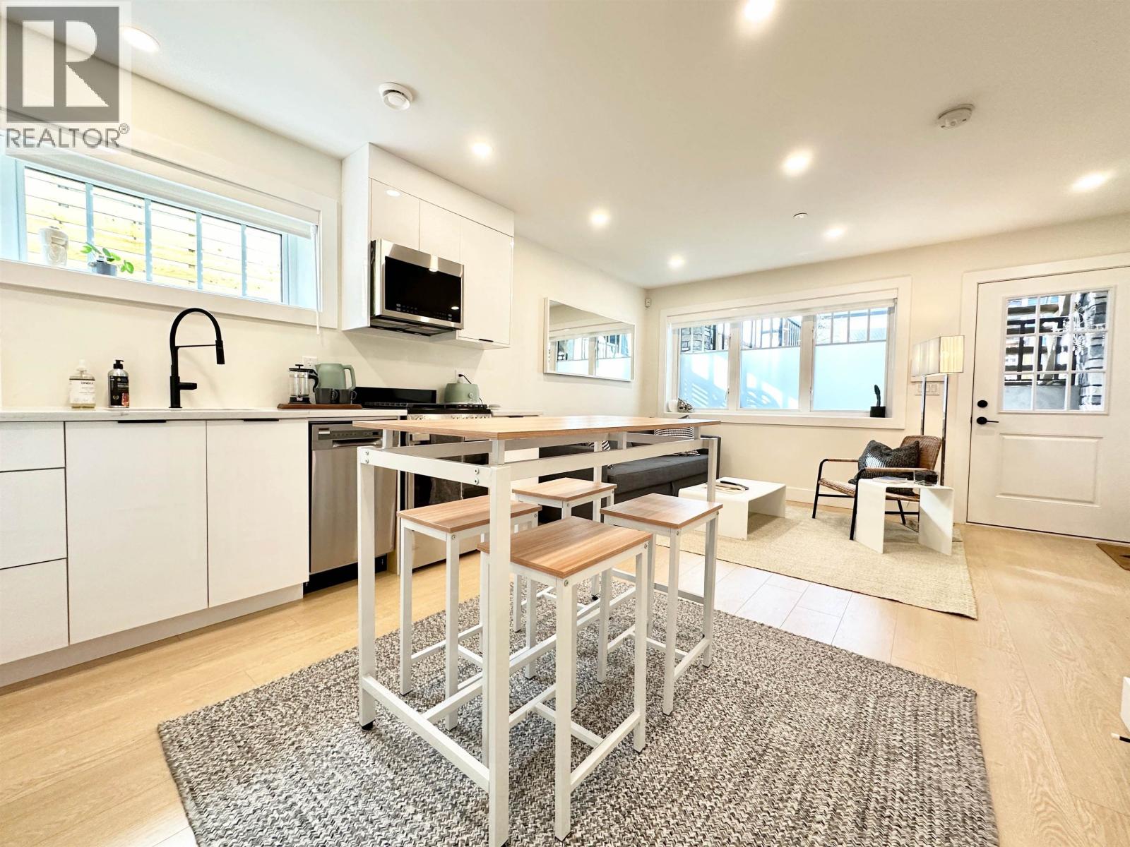 A modern kitchen with a dining table and chairs.