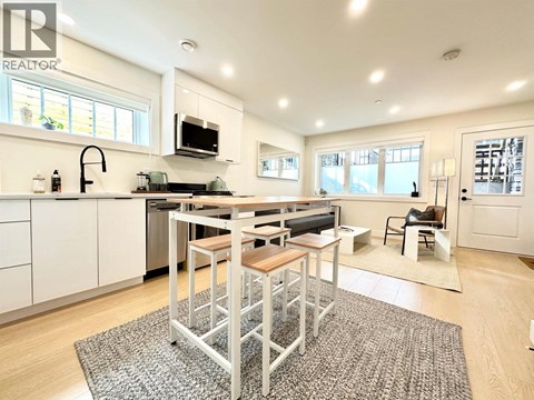 A modern kitchen with a dining table and chairs.