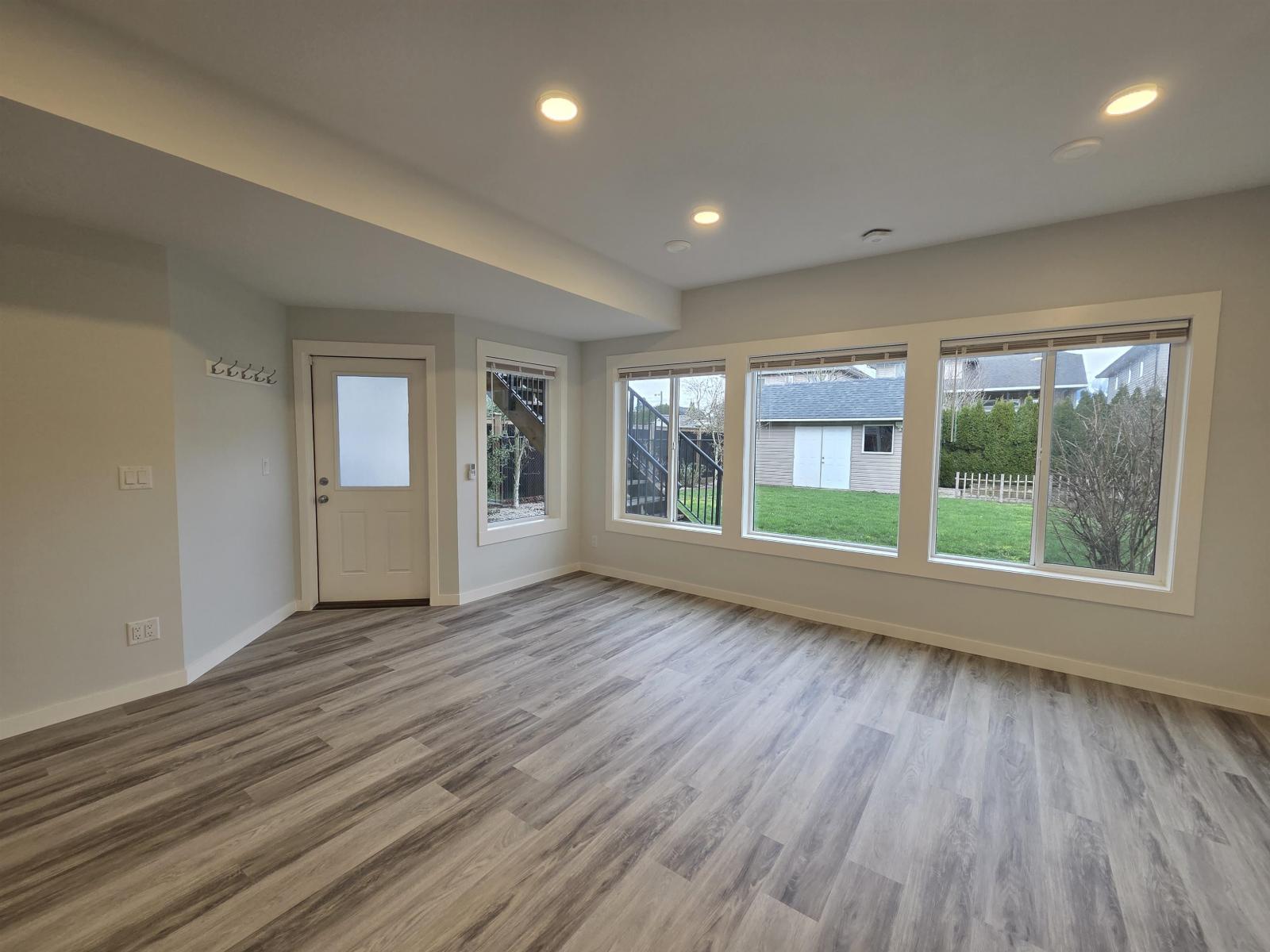 A room with wooden flooring and a white door.