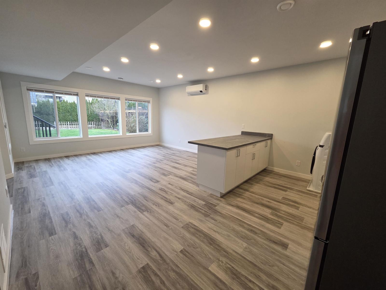 A kitchen with a refrigerator on the right side.