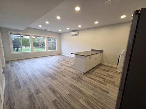 A kitchen with a refrigerator on the right side.
