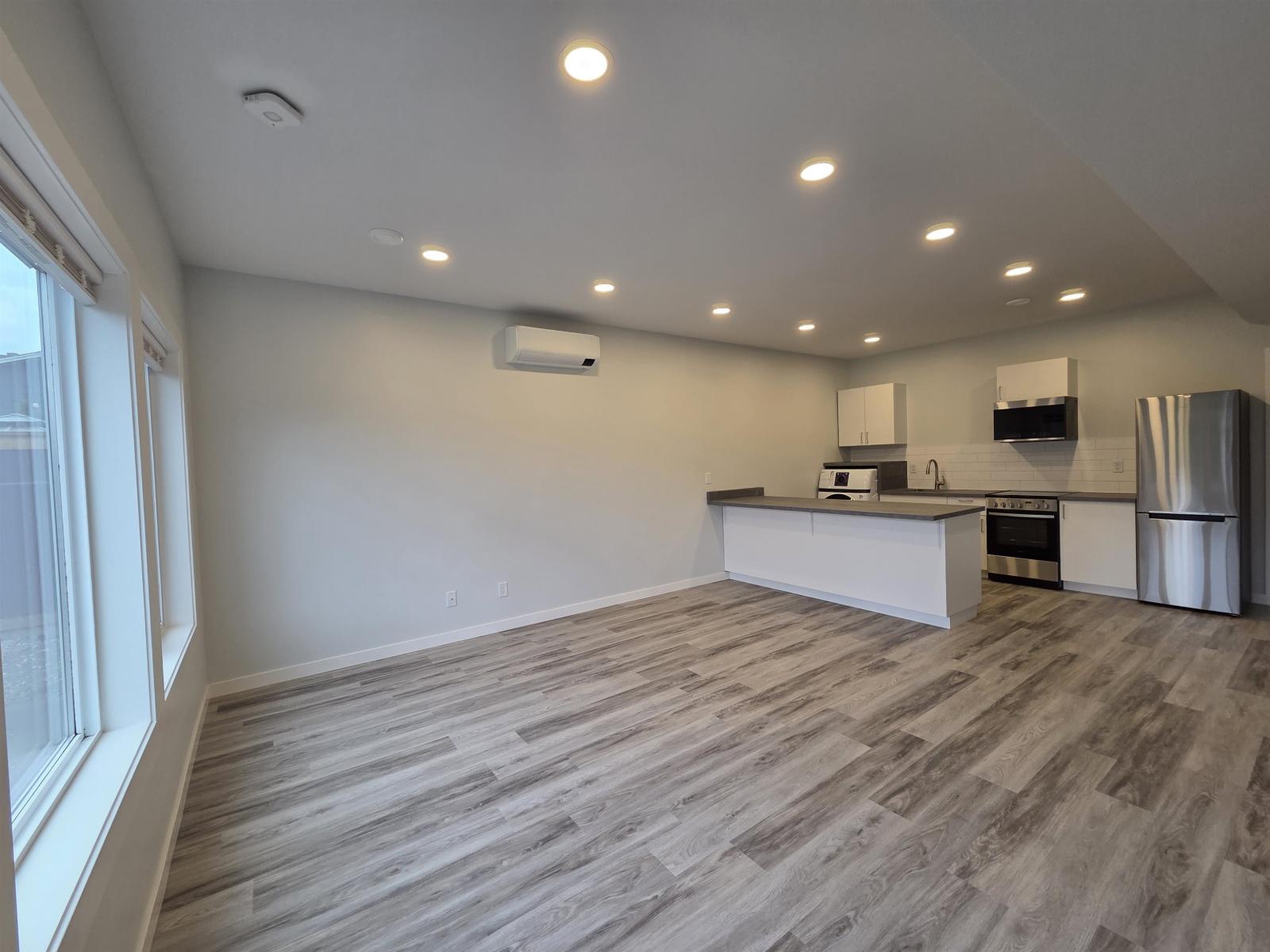 A kitchen with a refrigerator, oven, and microwave.
