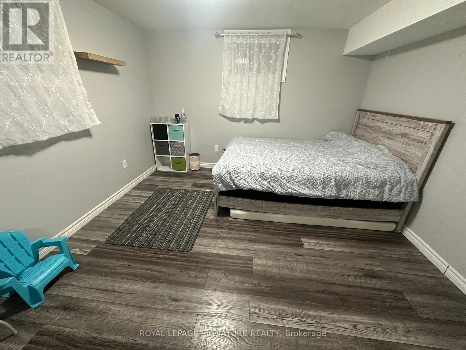 A bedroom with a bed, nightstand, and chair.