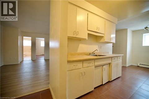 A kitchen with white cabinets and a wooden floor.
