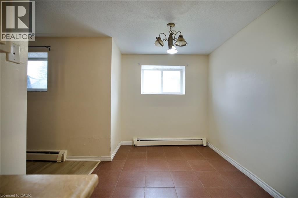 A room with a brown floor and a chandelier.