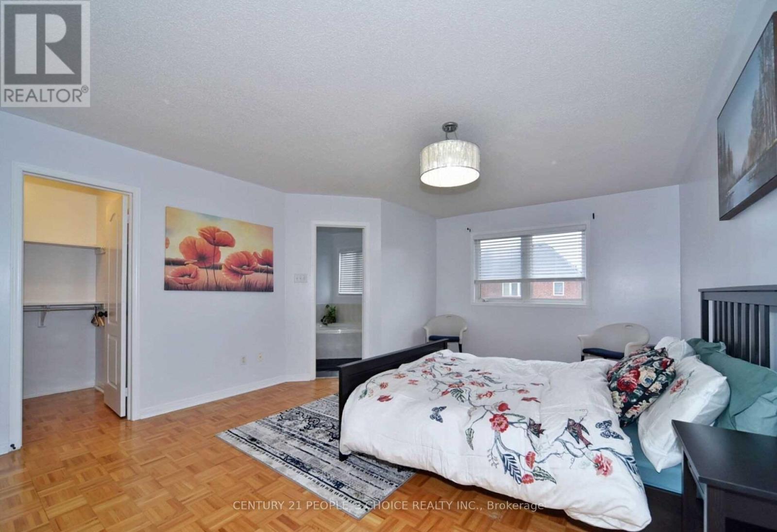 A bedroom with a bed, a chair, and a painting on the wall.