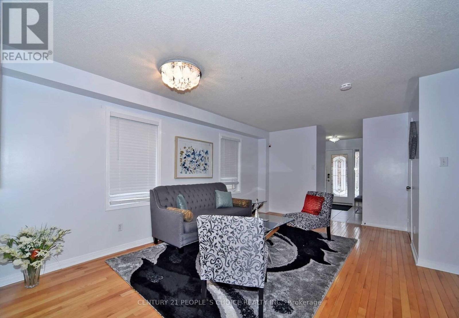 A living room with a grey couch and a black and white patterned chair.