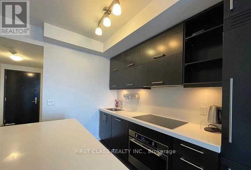 A modern kitchen with black cabinets and a white countertop.