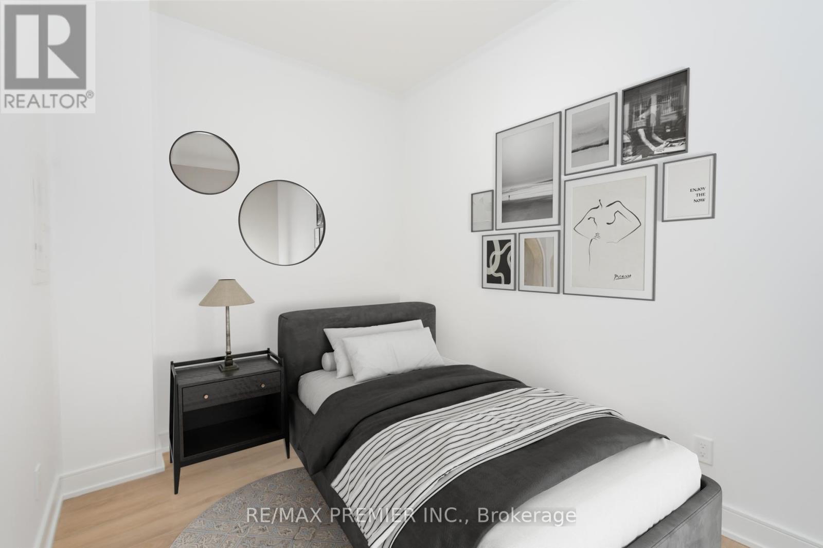 A bedroom with a bed, nightstand, and pictures on the wall.