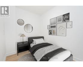 A bedroom with a bed, nightstand, and pictures on the wall.