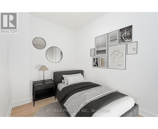 A bedroom with a bed, nightstand, and pictures on the wall.